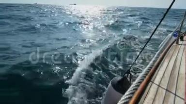 漂亮的木制游艇破浪<strong>前行</strong>，慢镜头.. 清澈的蓝色海水。 海浪溅起的浪花